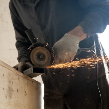Close Up Of Cutting Metal Pipe, Man Using Angle Grinder. Hot work permits.